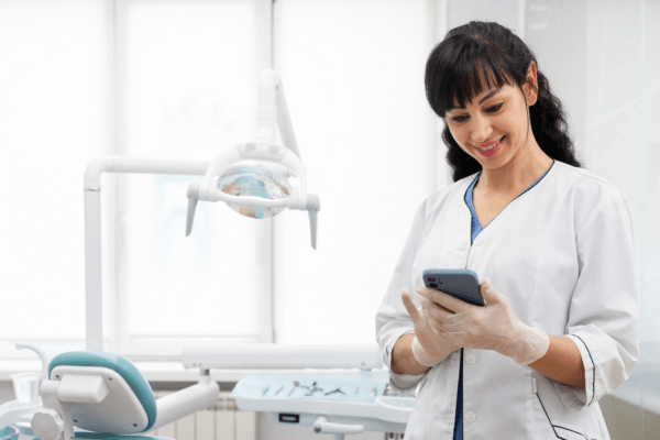 An employee uses a dental office phone system to enhance productivity.