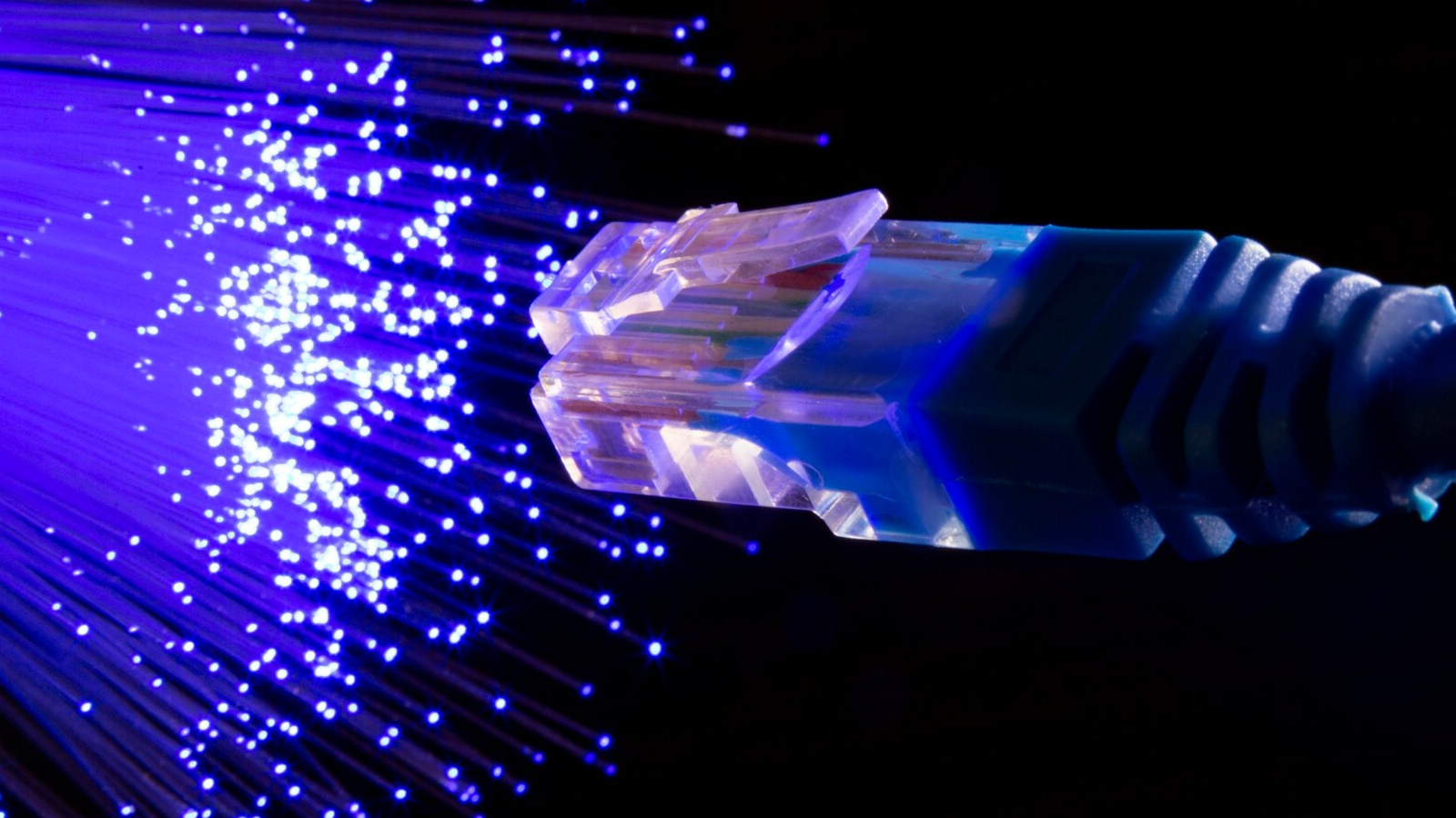 Small Business, Big Demands: The Case for Upgrading to Business Internet Now 4 Close-up of fiber optic cable glowing with blue light near an Ethernet connector, representing fast, symmetric internet connections.