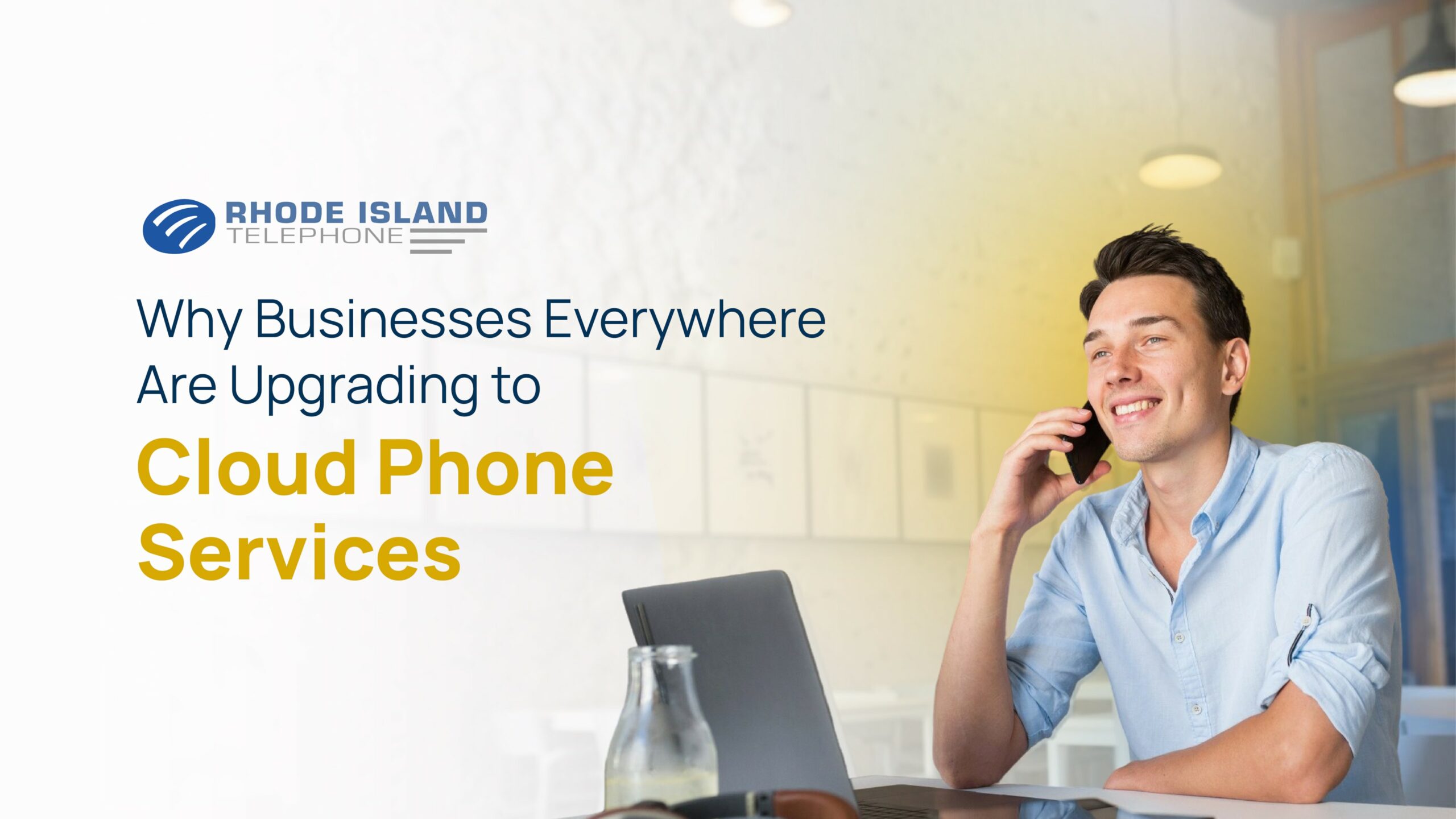 A man sitting at a desk talks on a cell phone.  The background has a blue and yellow hue to it, but fades to white on the left side of the image where the Rhode Island Telephone logo sits along with text reading the title of the blog: Why Businesses Everywhere Are Upgrading to Cloud Phone Services. 