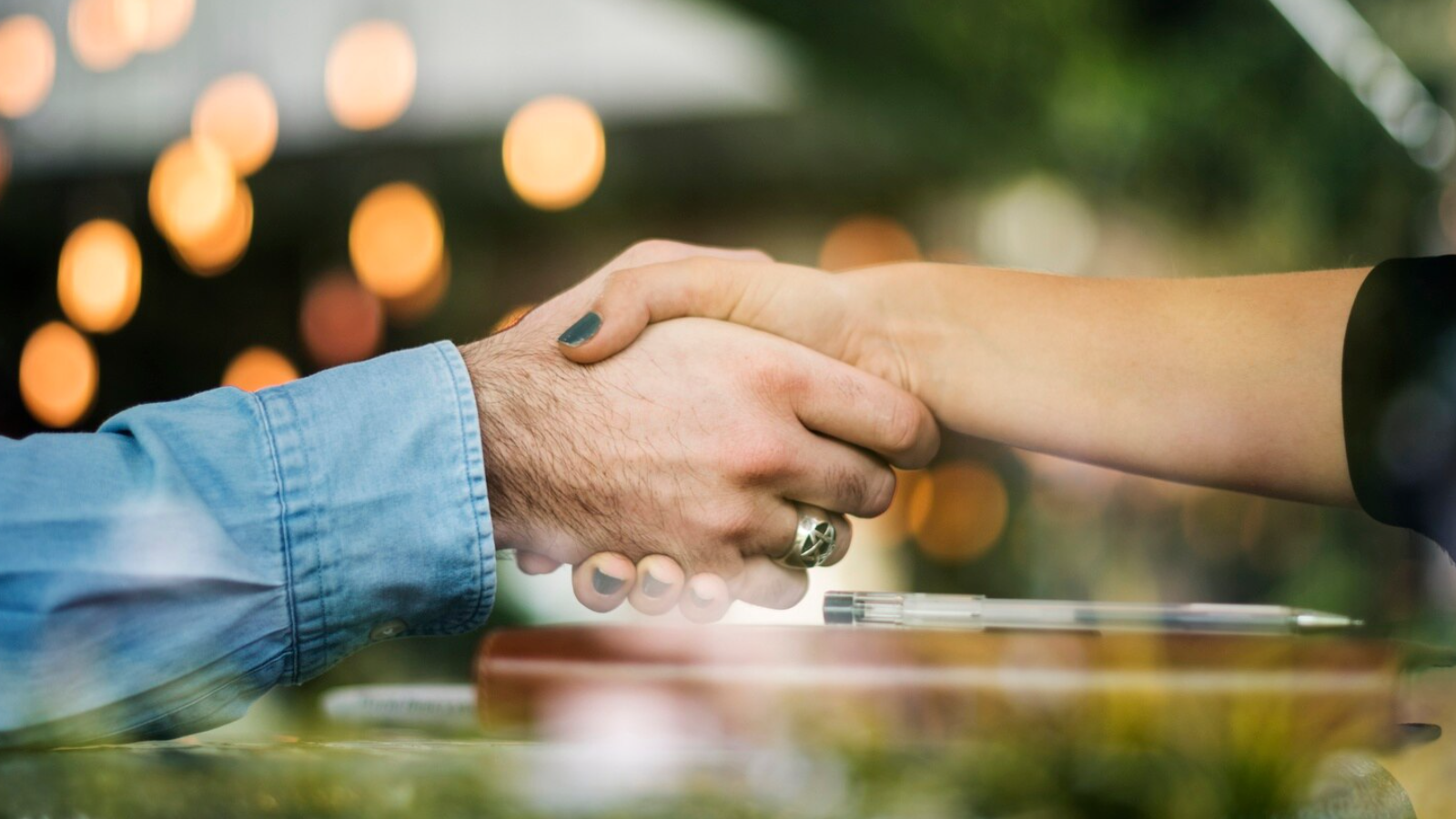 Close-up handshake over a contract, symbolizing how a local telecom company helps the banking industry with secure, business-ready solutions.