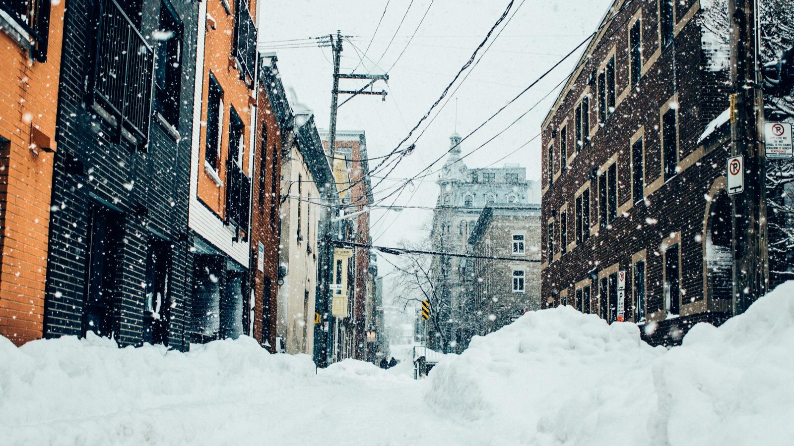 Snow-covered city street in New England with banks and businesses nearly buried, reflecting the need for resilient digital banking solutions.